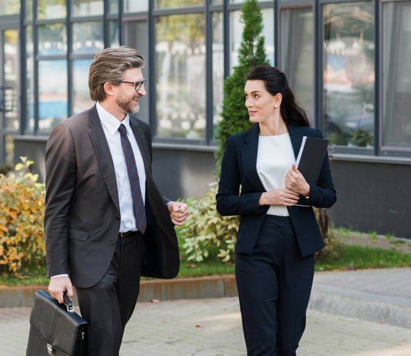 Business man and woman walking past building